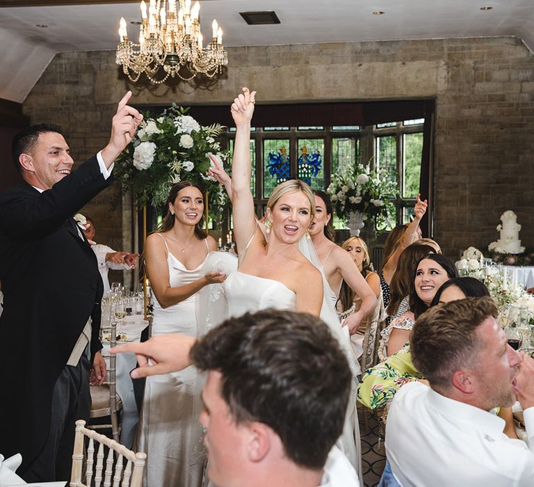 The wedding guests celebrate together for their wedding reception with the wedding band playing 