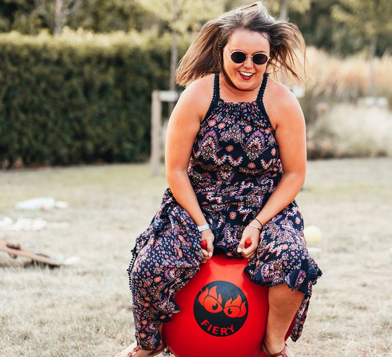 A wedding guest enjoys the wedding entertainment by making use of the space hoppers at Rackleys Chiltern Hills barn wedding venue 