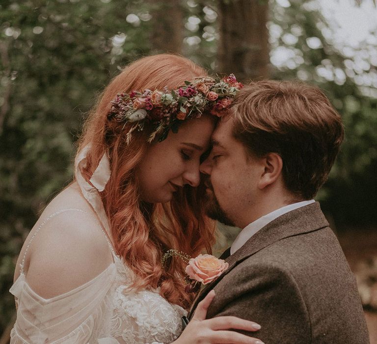 Lila's Wood wedding with the bride wearing a floral lace wedding dress and pink flower crown with the groom in tweed suit 