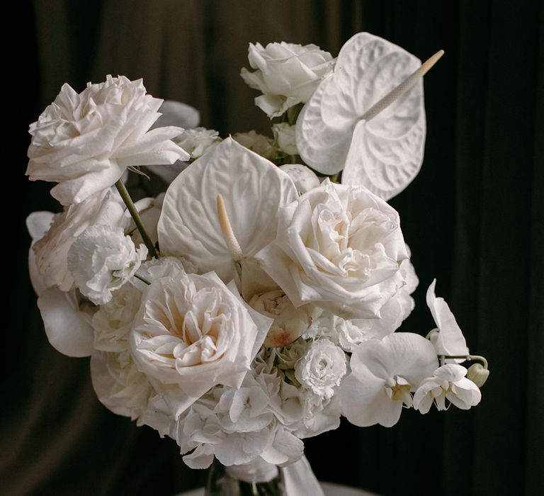 The bride's luxe white wedding bouquet with roses, orchids, anthuriums and hydrangea 