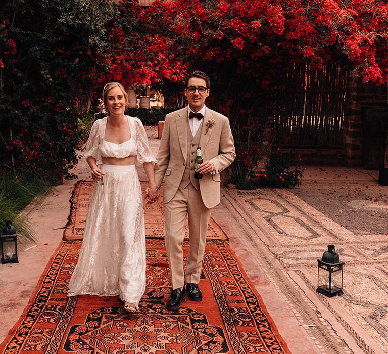 Destination in Marrakech, Morocco with the bride in two piece set and groom walking together 