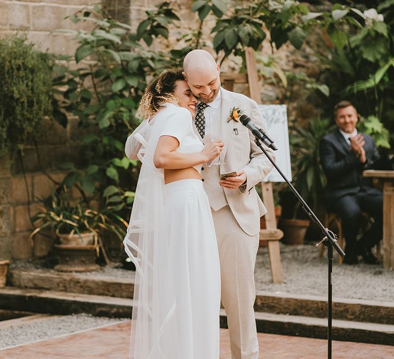 The bride and groom perform a wedding speech together and share an intimate moment 