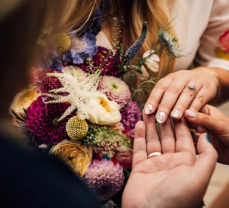 Bride with white wedding nails decorated with mini wildflowers to match the botanical seasonal wedding theme 