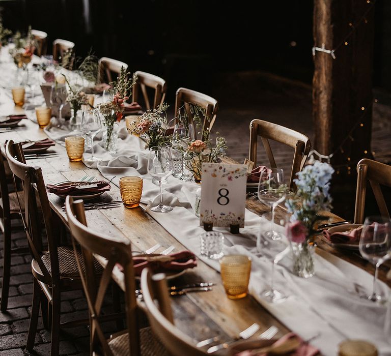 Wedding table decorated with yellow glassware and pastel blue wedding flowers 