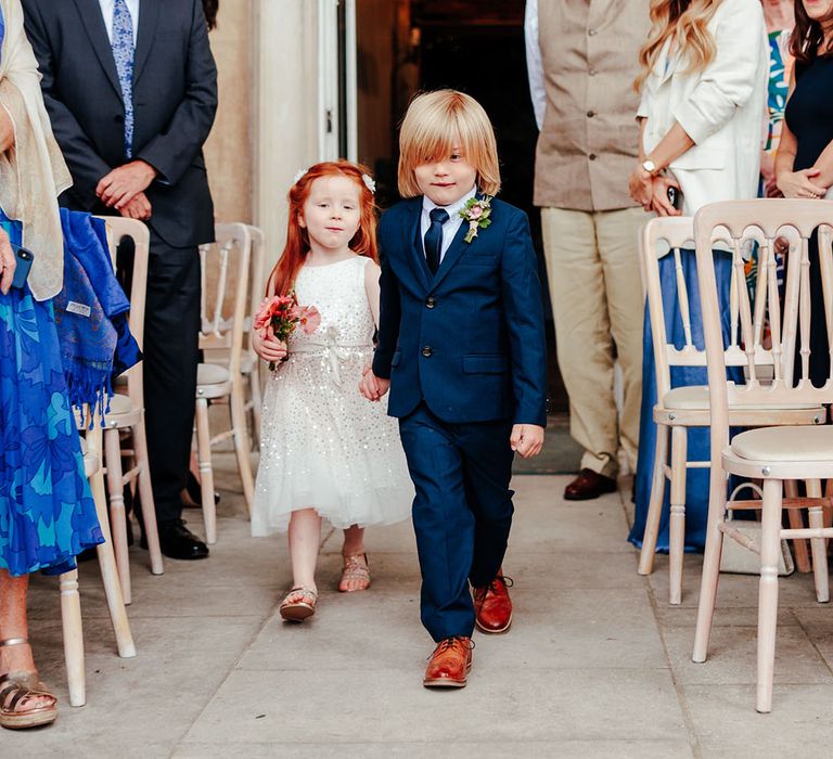 The flower girl and page boy walk down the aisle 