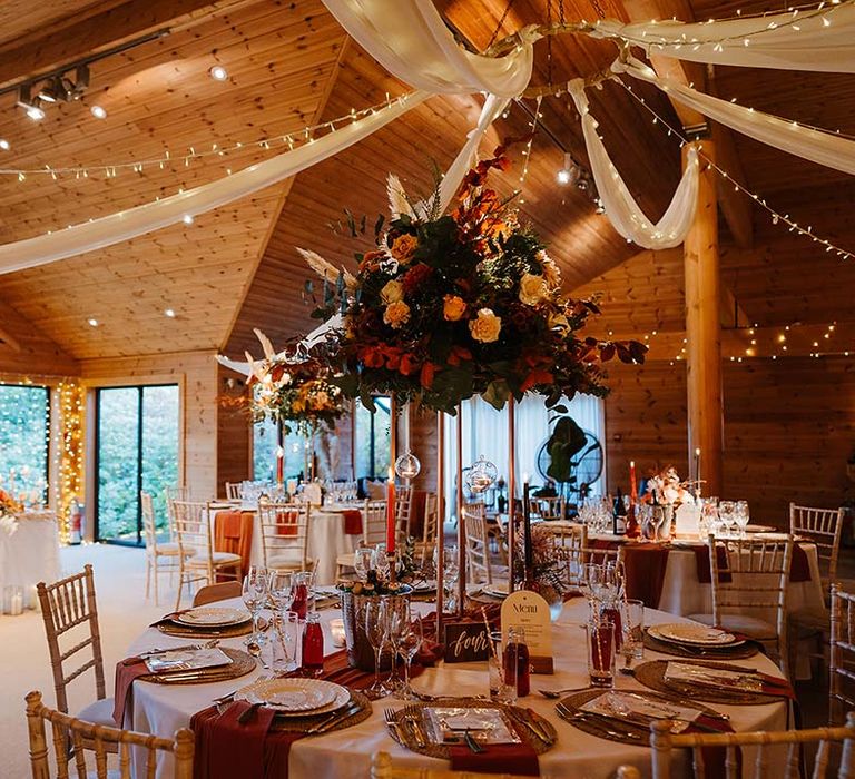 Styal Lodge with white drapery, fairy lights and orange and gold autumnal wedding table decor at Styal Lodge 