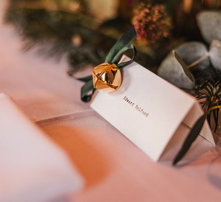 Simplistic wedding place name with gold bells and green velvet ribbon 