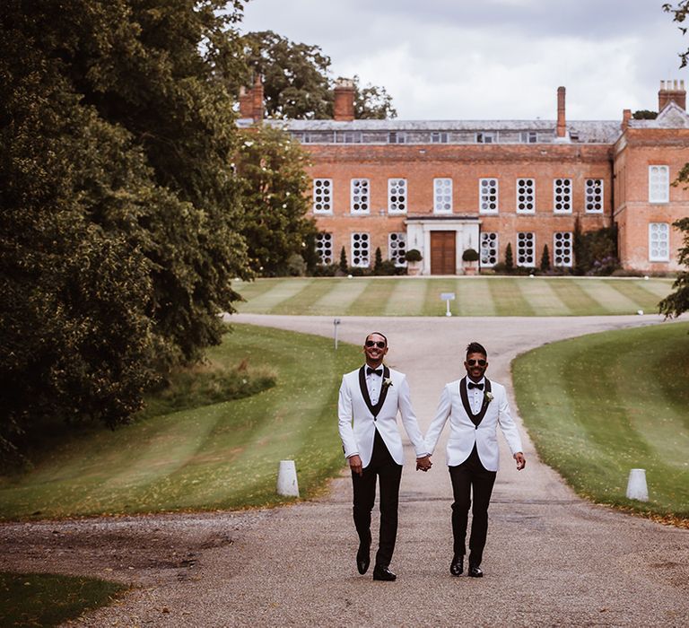 Two grooms at gay wedding at Braxted Park with matching white wedding tuxedos 