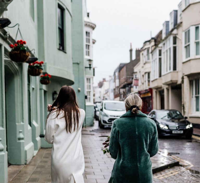 Bride in ivory coat and mother o the bride in green faux fur coat 