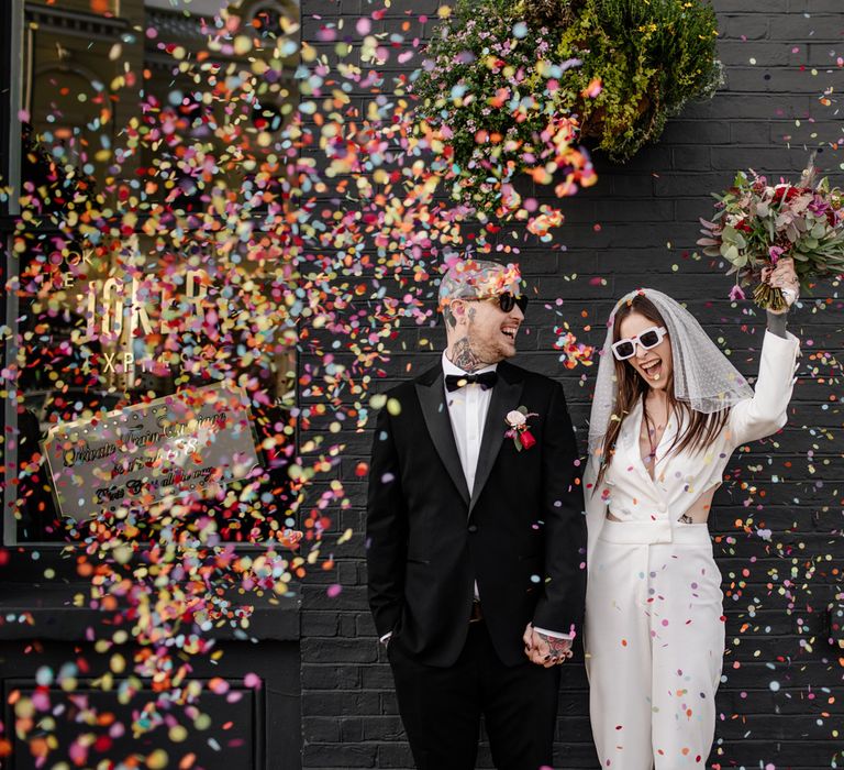 Colourful confetti moment for alternative couple at pub wedding reception 