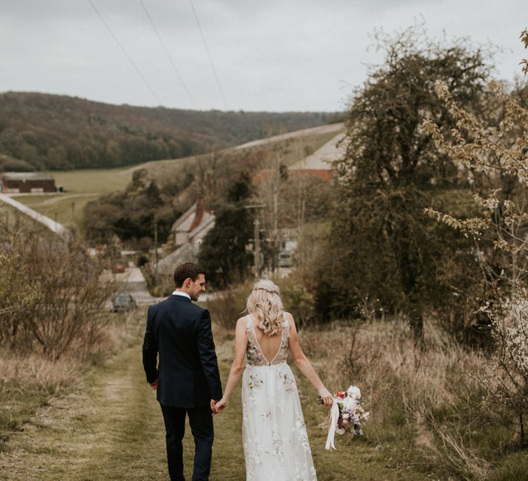 Bride and groom holding hands at Spring wedding 