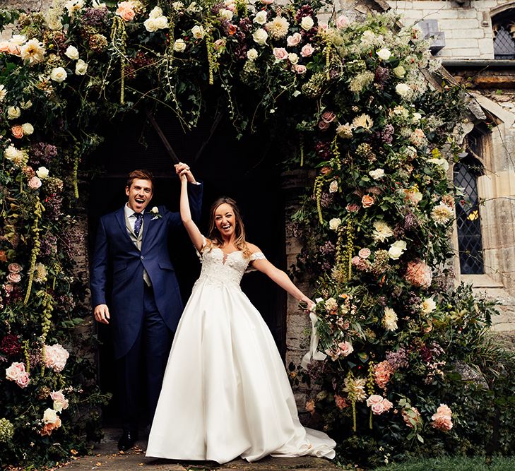 Happy couple with floral flower arch 