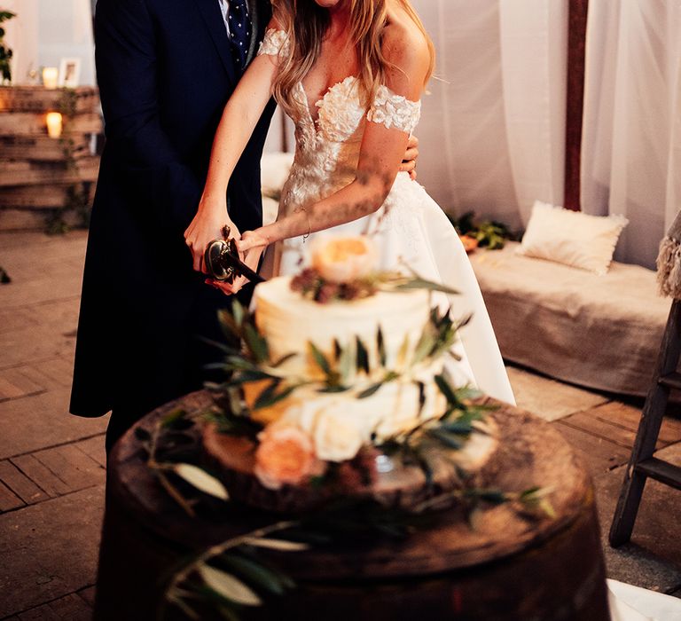 Bride and groom cutting wedding cake at barn countryside wedding