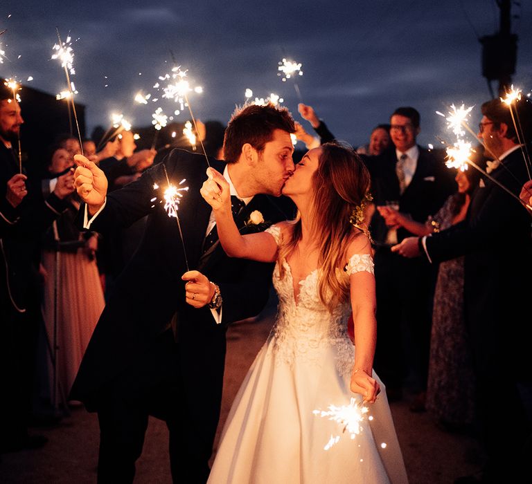 Evening wedding celebrations with sparklers and cold shoulder wedding dress 