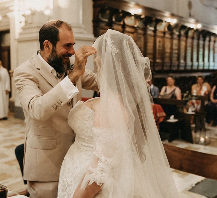 Groom lifting Bride's Blossom & Bluebird veil