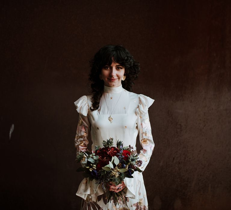 Bride clutches Winter bouquet wearing Mary Benson wedding dress