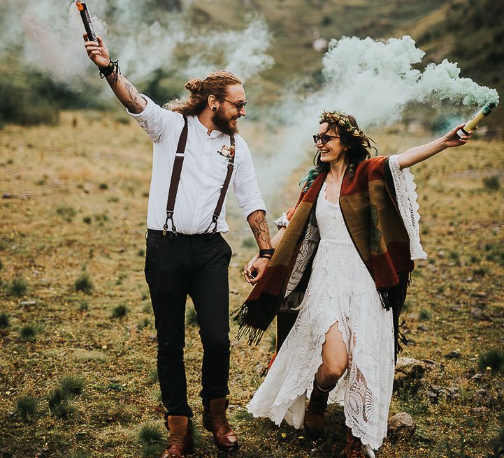 Bride & groom carry coloured smoke bombs in the Lake District