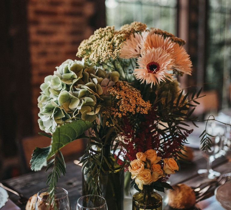 Green hydrangea and Pink transvaal daisy wedding flowers in bottles 