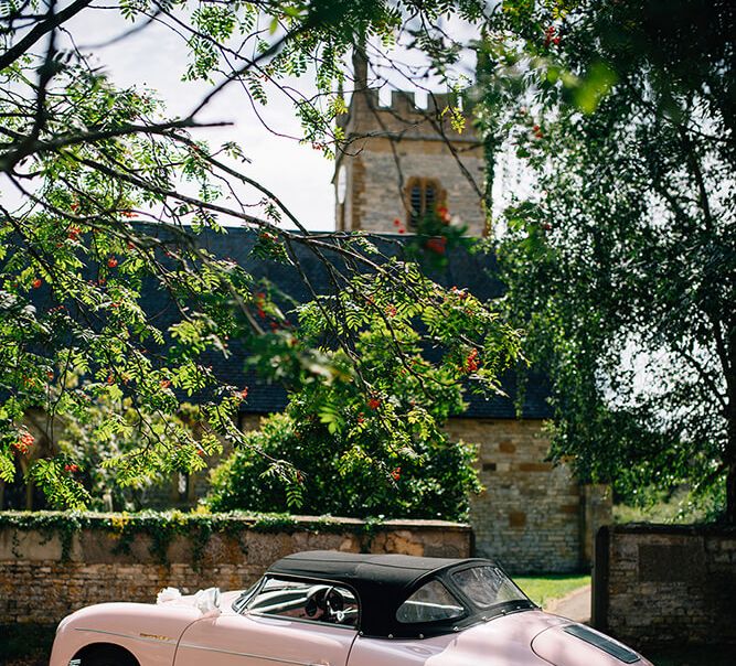 Soft top Pale pink porsche outside church wedding in Warwickshire