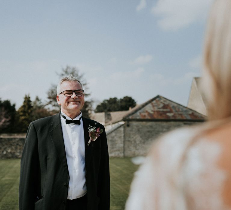 Father of the bride in black suit sees bride in white Charlie Brear wedding dress for the first time as Caswell House wedding