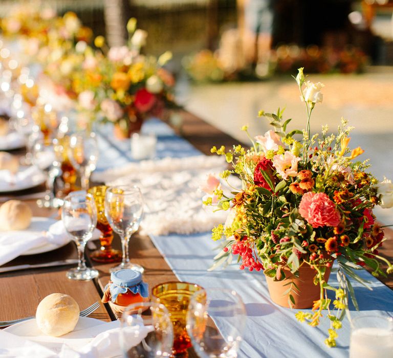 Terracotta pots filled with plants as minimal table centrepieces for a destination wedding in Greece