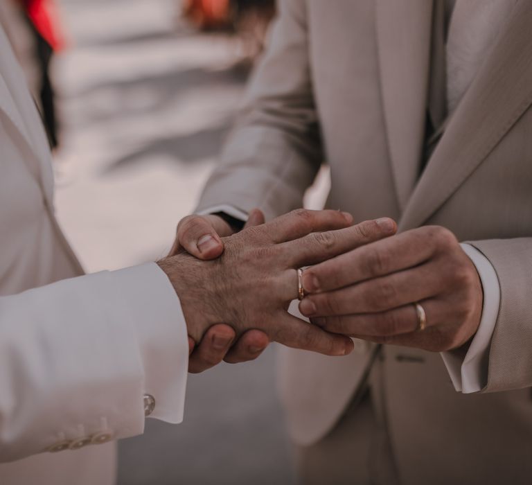 Grooms exchange rings at gay wedding