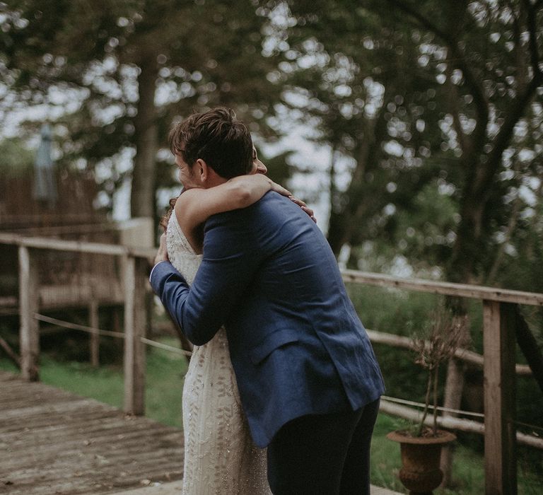 Groom embraces bride outdoors during first look moment