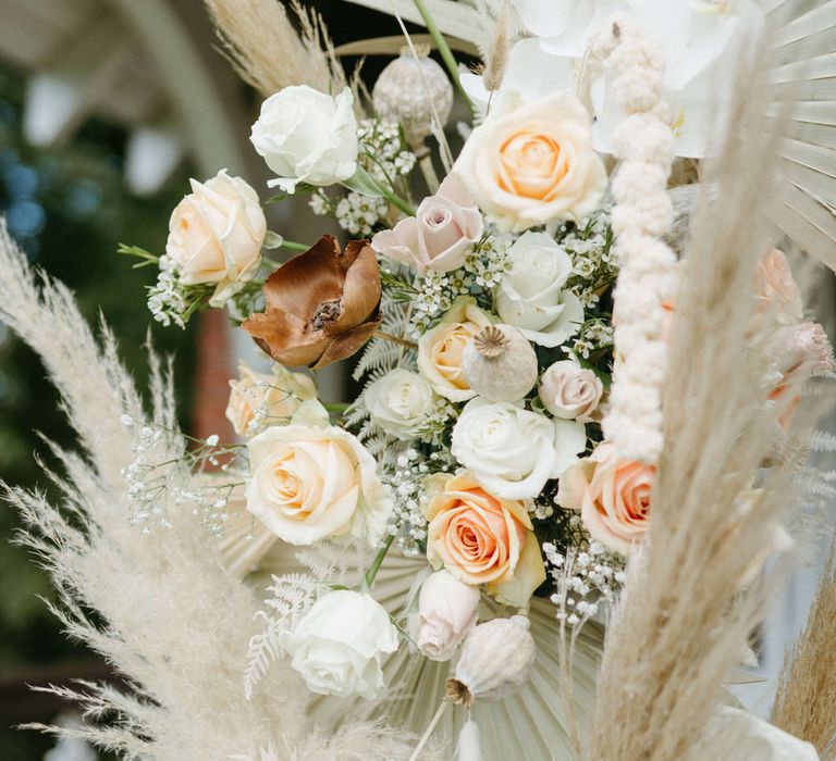 Flower archway detail of dried palms, pampas grass, roses, dried poppy heads and white anthuriums