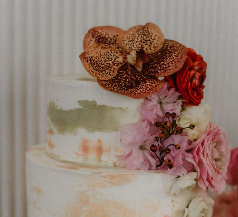 Two tier brush effect wedding cake with pink flower decorations