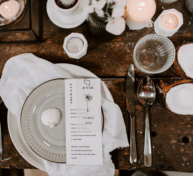 Black and white tropical wedding tablescape with neutral ceramics