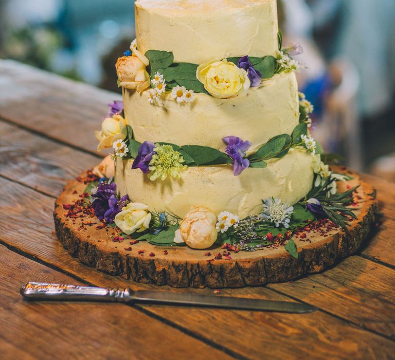 Floral decorated wedding cake complete with white frosting with rustic vibe | Story + Colour