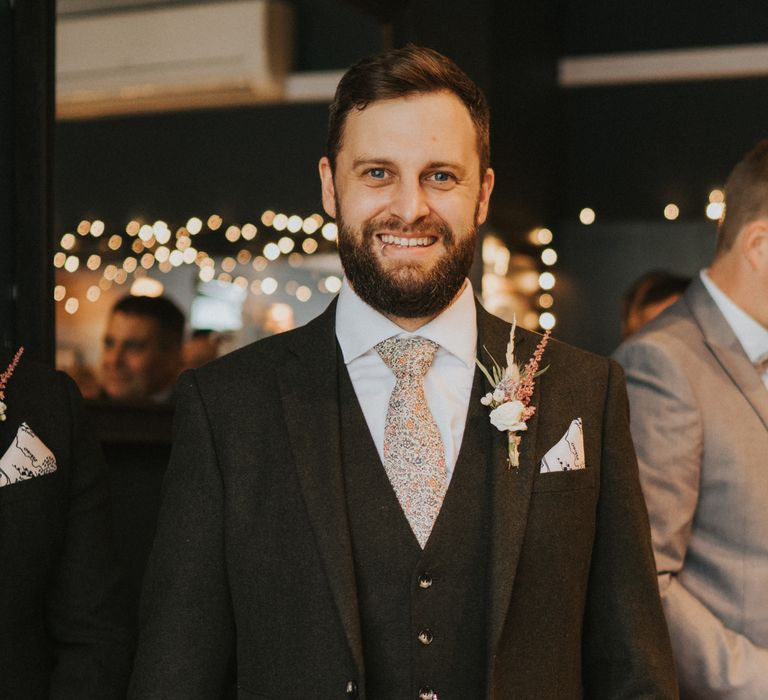 Groom with patterned tie, floral buttonhole and pocket watch