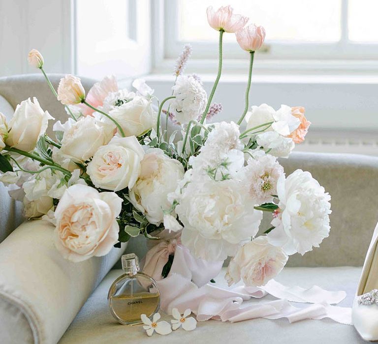 Bridal bouquet with white roses and peonies and the bridal shoes and perfume accessories 