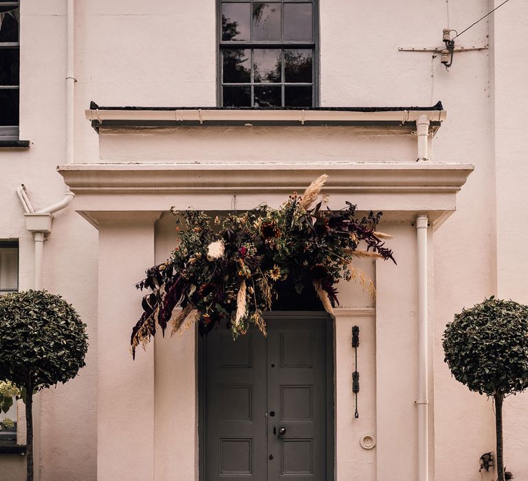 Exterior of White House in Cornwall decorated for wedding reception with floral cloud above door