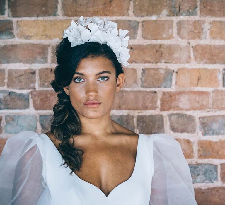 beautiful bride with natural makeup, side plait and white appliqué flower headband 