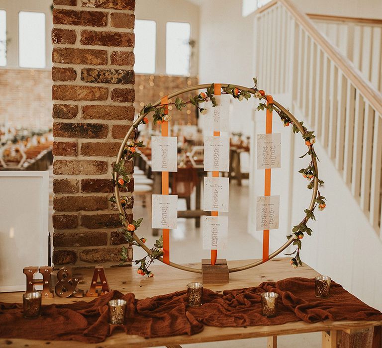 Hoop wedding table seating plan with orange ribbon