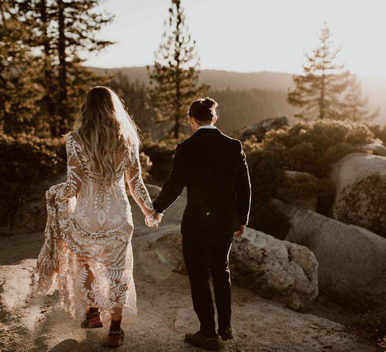 Bride & groom walk hand in hand with one another