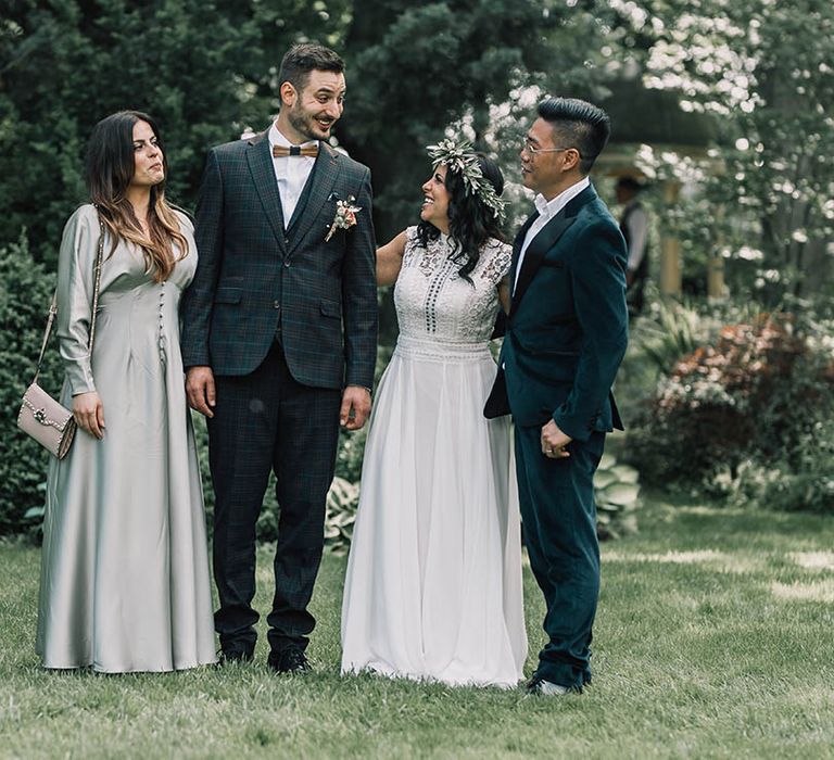 Bride & groom stand with wedding guests outdoors on their wedding day