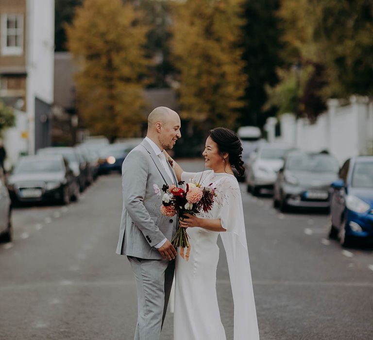 Bride & groom walk down the street with one another after ceremony 