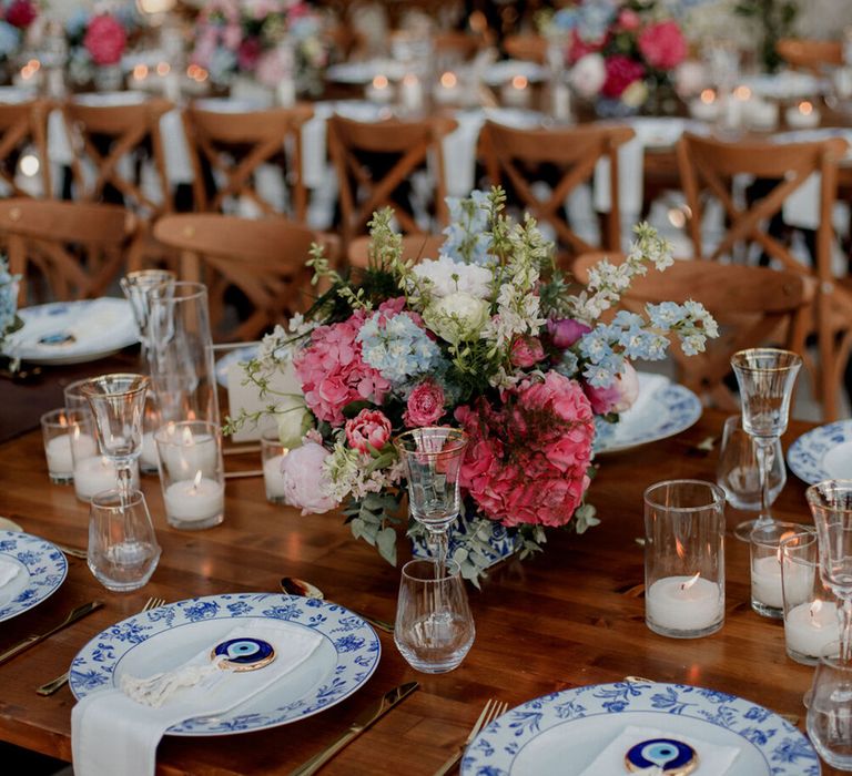 White and blue china plates complete with evil eye decorative piece and bright florals 