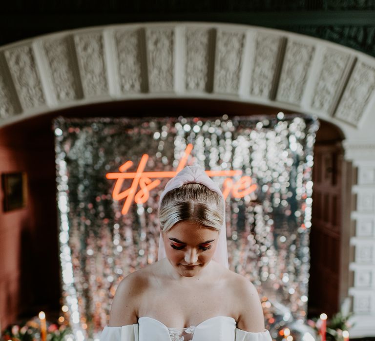 Bride in a strapless wedding dress with plunging lace neckline holding a red and orange tulip bouquet 