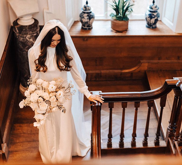 Jessamy Stoddart wedding at Iscoyd Park with a long sleeve wedding dress, cathedral length veil and all-white wedding bouquet 