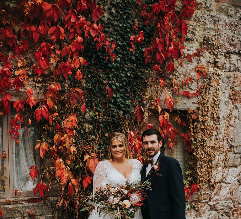 autumn theme wedding at Askham Hall with curvy bride in a princess wedding dress and groom in a navy suit 