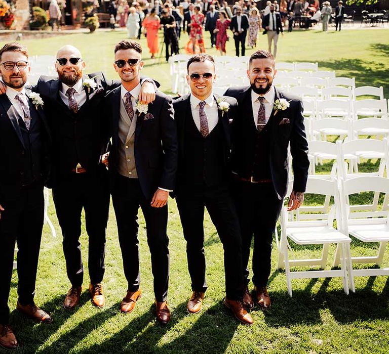 Groom and groomsmen wearing sunglasses on summer wedding day