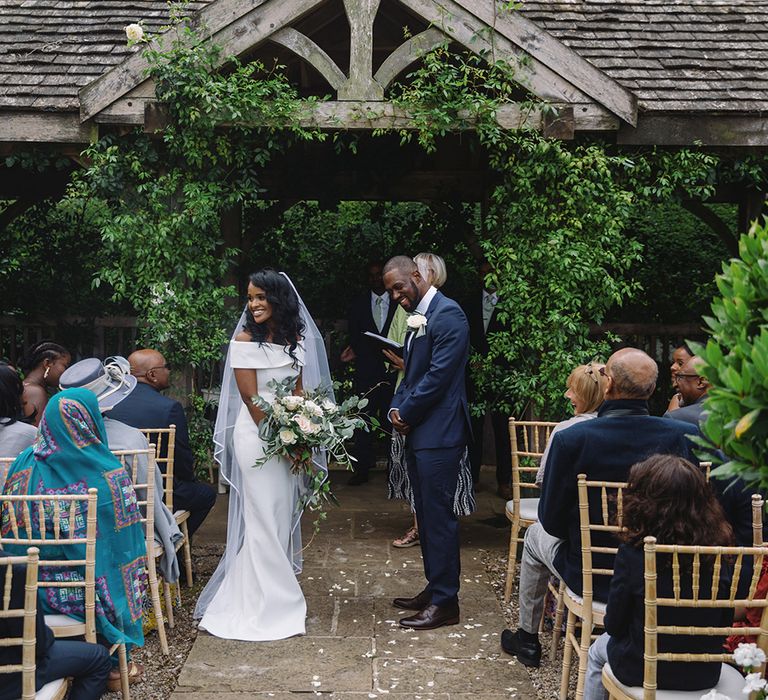 Bride and groom at outdoor Sudanese wedding ceremony standing at the altar together 