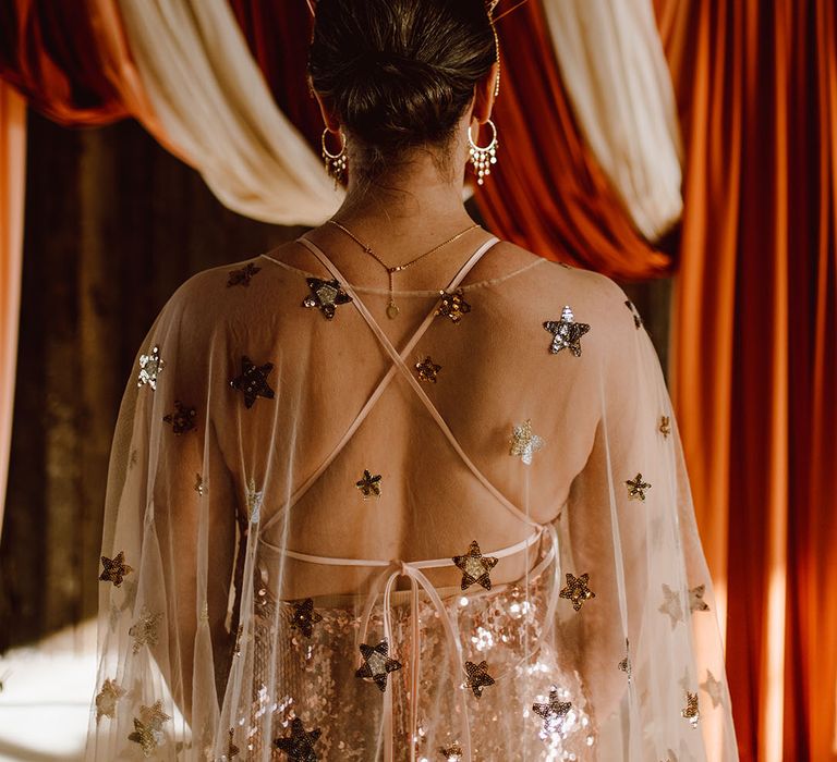 Bride in a gold celestial wedding dress and crown with embroidered star design 