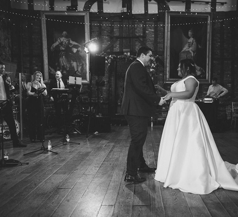 Bride and groom share their first dance as the live wedding band plays 