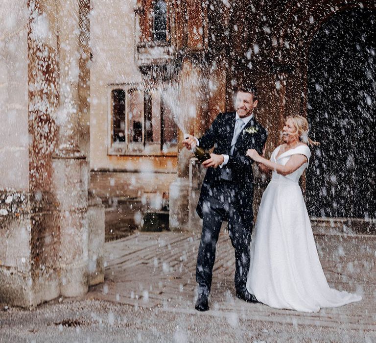 Bride and groom wedding photograph popping champagne 