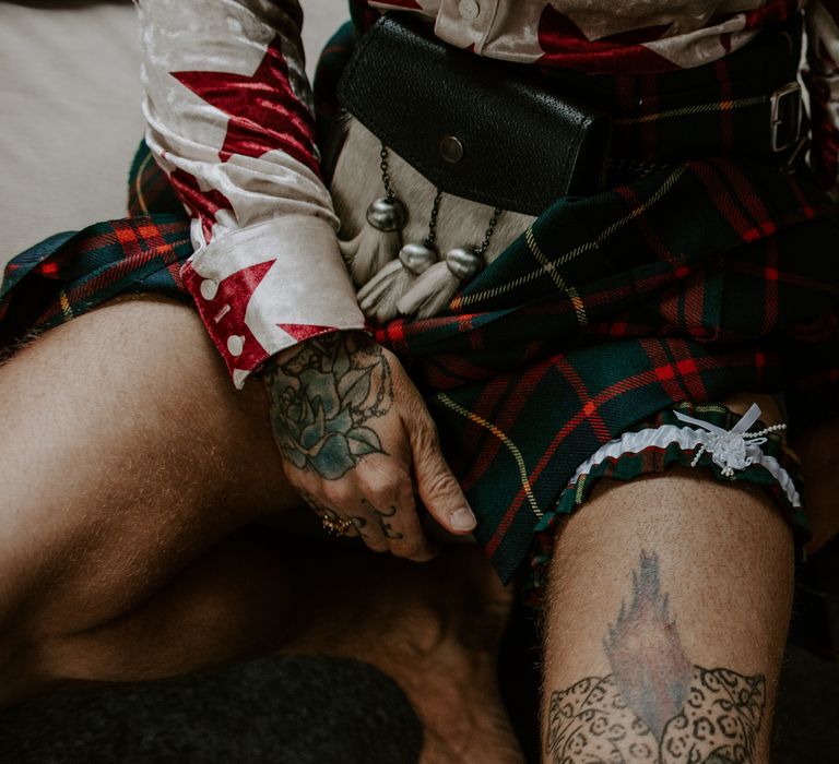 Groom wears tartan kilt and garter on the morning of his wedding day