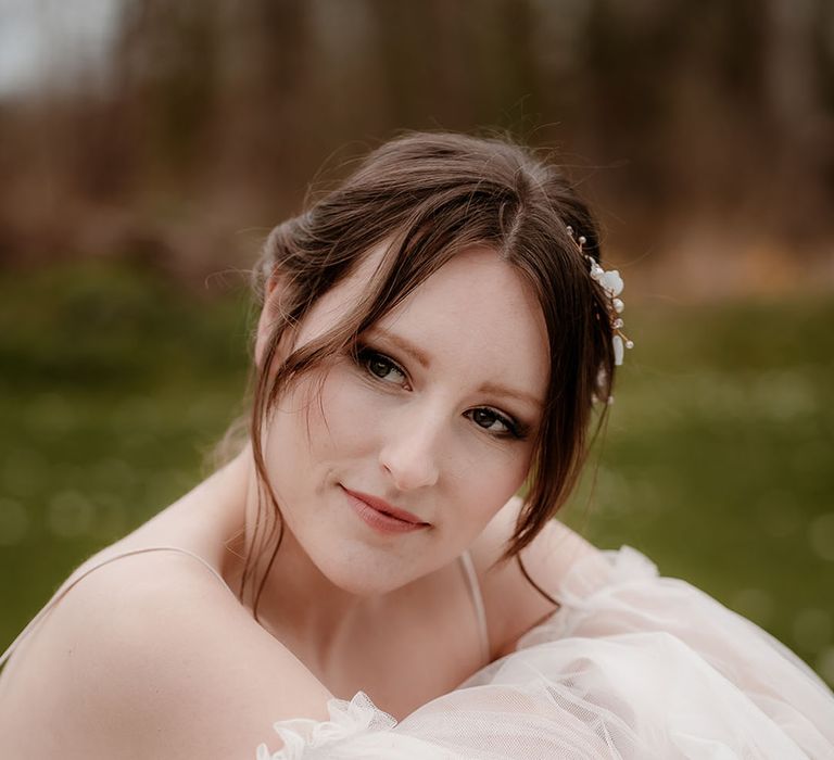 Bride in an ethereal wedding dress with long sheer sleeves and natural bridal makeup 